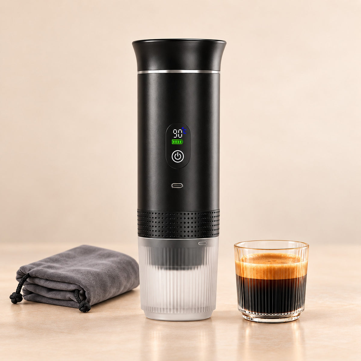Black 2.0 portable espresso maker with digital display, grey drawstring travel bag and a glass of espresso