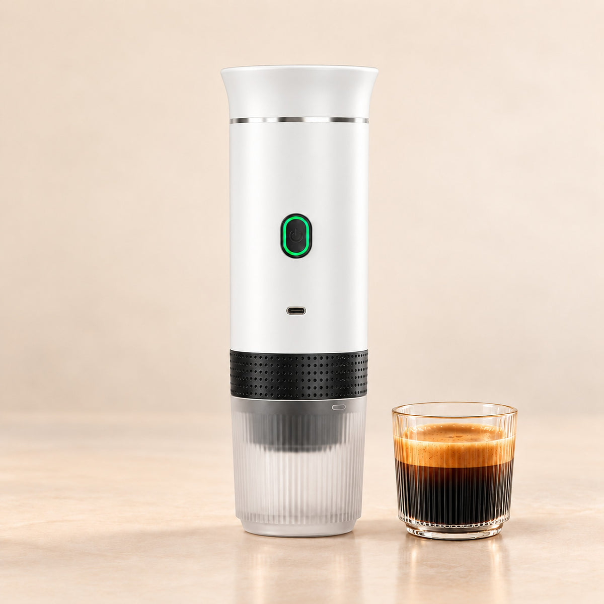 White portable espresso maker with a glass of fresh espresso