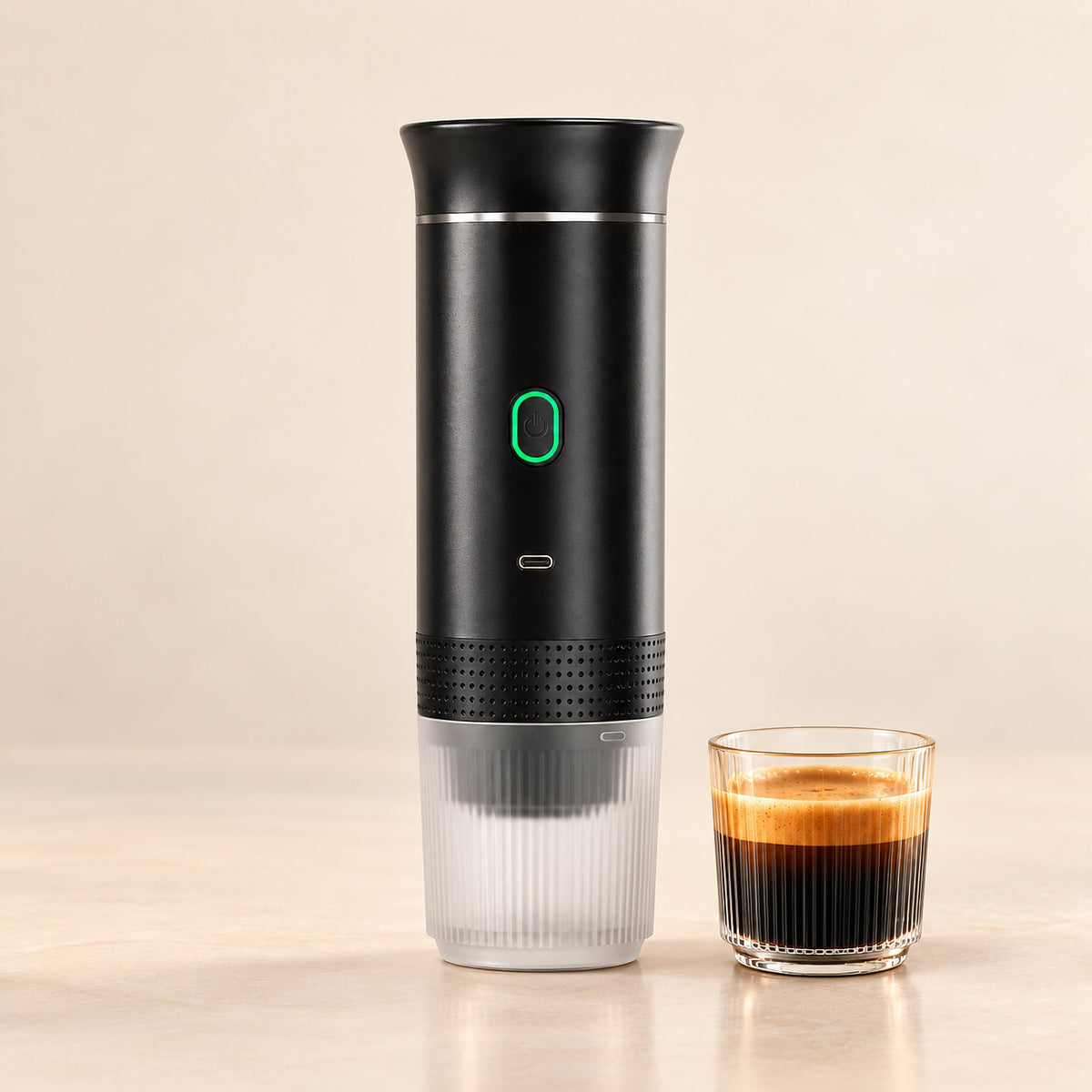 Black portable espresso maker with a glass of fresh espresso